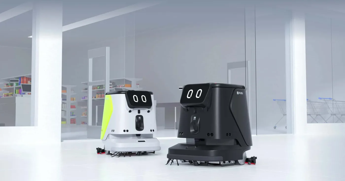 Two floor-cleaning robots in a retail interior