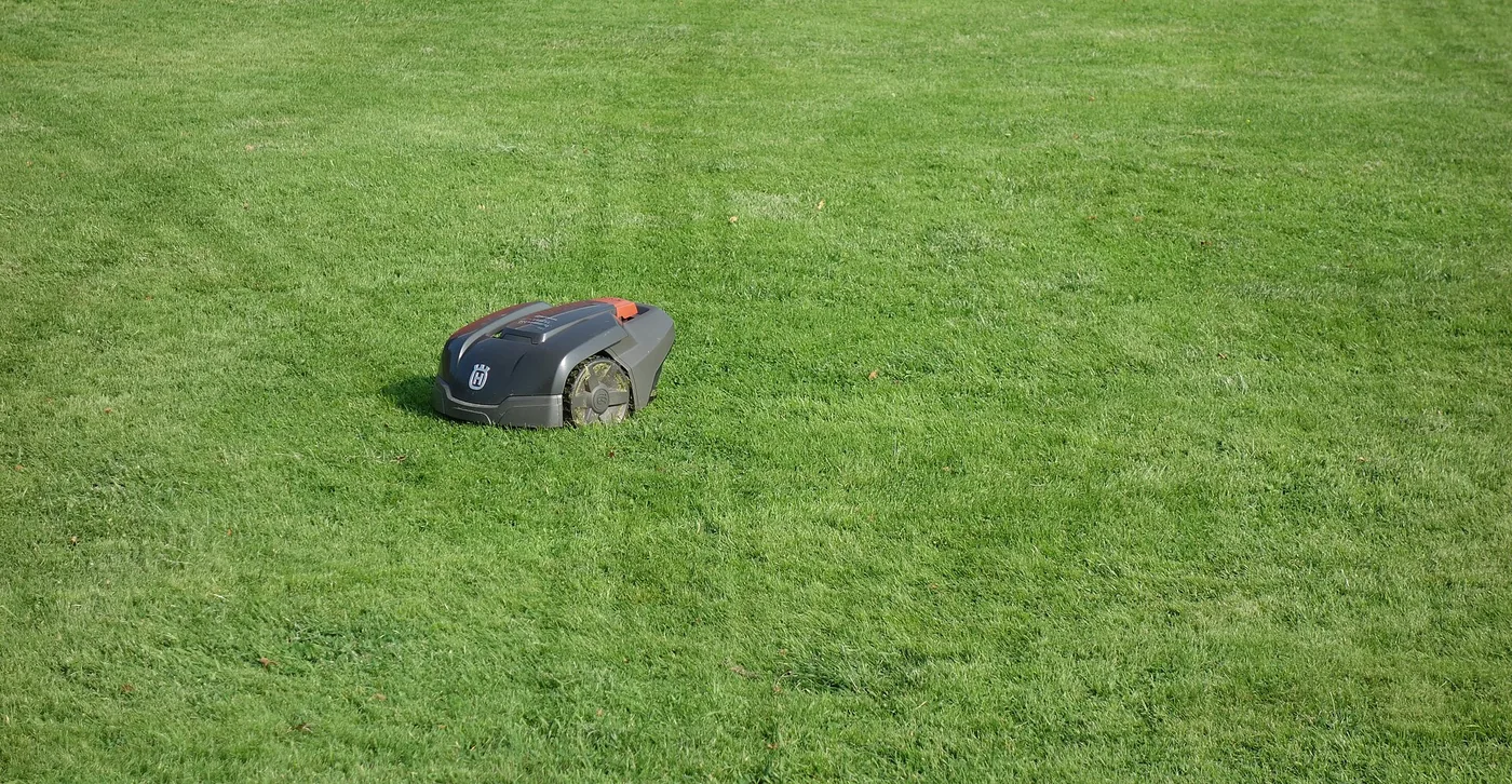 A robotic mower cutting a large open lawn
