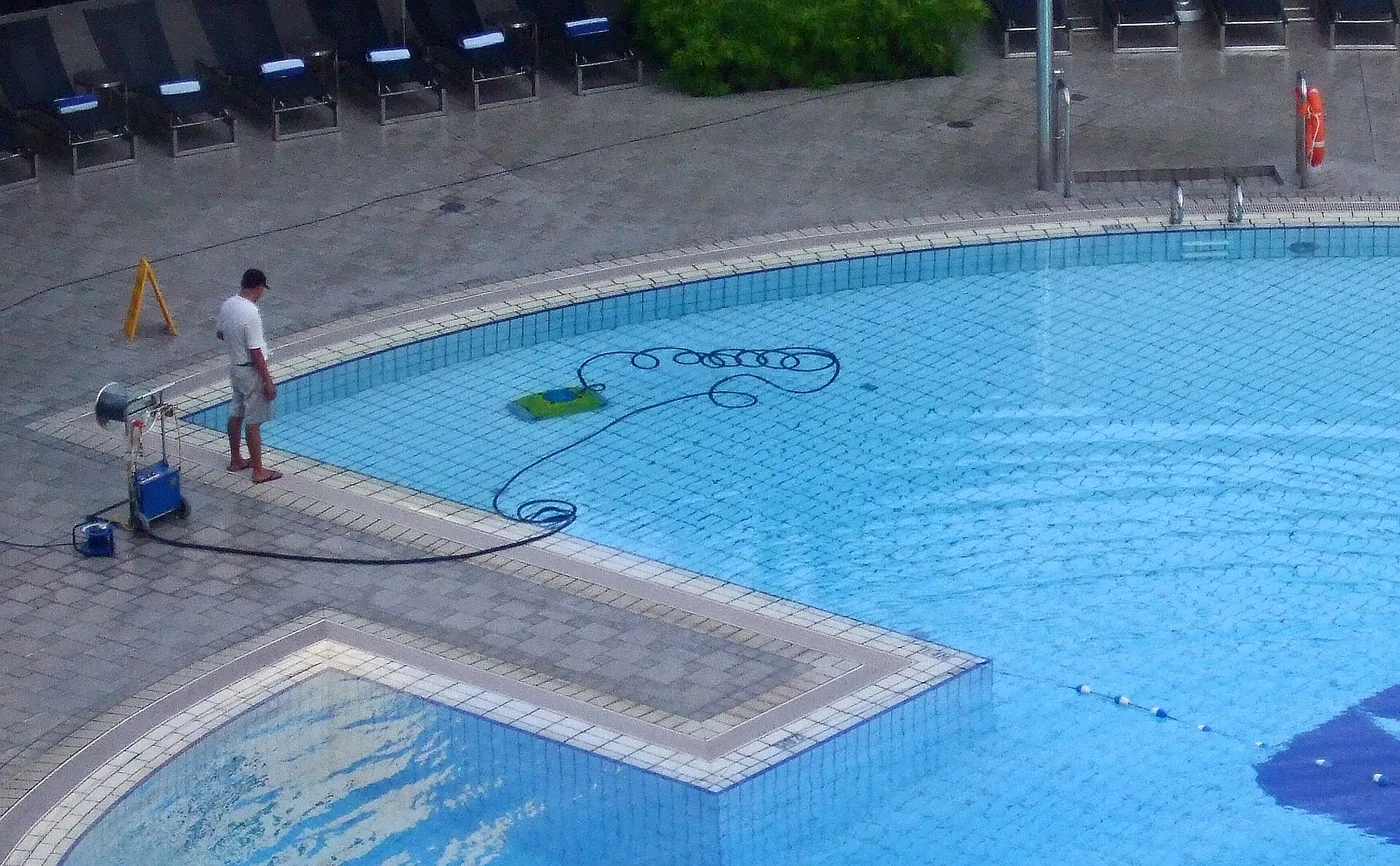 A robotic pool cleaner working the floor of a swimming pool